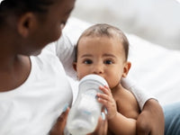 Mom feeding baby with bottle of milk