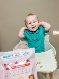 Child in green polo shirt enjoying a bag of RSF! Organic Puffs