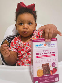 Baby Chaylen holding box of RSF! Peanut Butter Strawberry bars