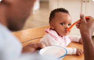 Dad feeding baby with spoon