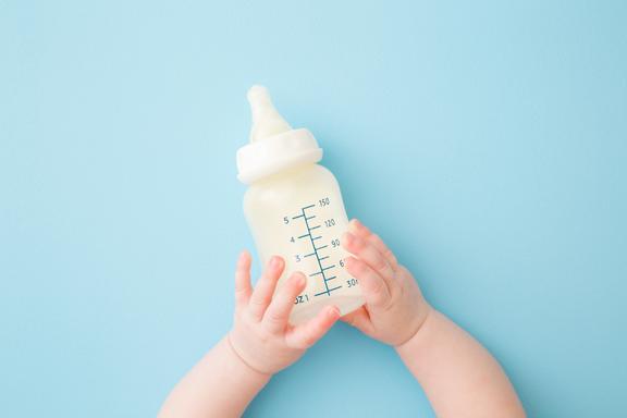 Baby holding milk bottle