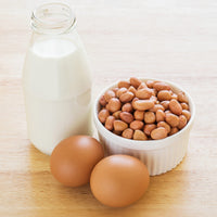 bowl of peanuts, 2 eggs and a bottle of milk 