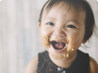 Baby with peanut butter all over face