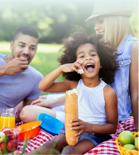 Family enjoying picnic with french bread and snacks