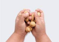 Baby's hands holding peanuts - mobile view
