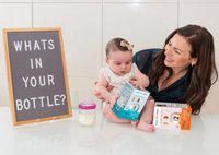 Mom and baby with a What's In Your Bottle sign